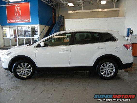 Side view of a white 2008 Mazda CX-9 parked inside a dealership