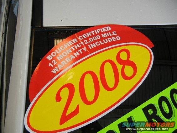 Red and yellow sticker on car window reads 'Boucher Certified 12 Month/12,000 Mile Warranty Included' and '2008'