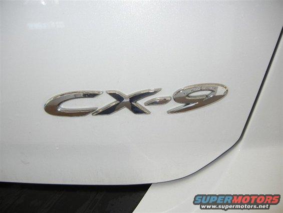 Close-up of a CX-9 badge on a white car's exterior panel