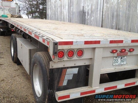 Rear view of a flatbed trailer with Fontaine branding and Illinois license plate 355 360S