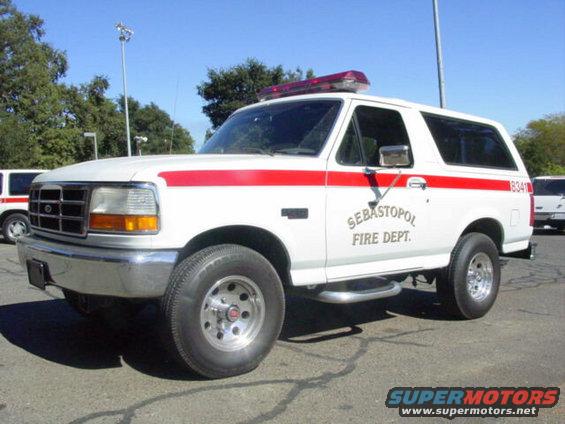 White 1992 Ford Bronco fire department vehicle with red stripe, "SEBASTOPOL FIRE DEPT." text, and light bar