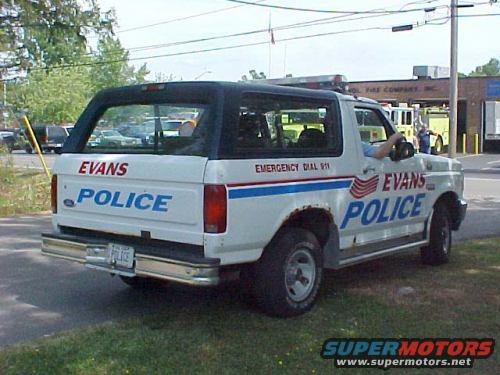 White Ford Bronco with EVANS POLICE markings and emergency lights on roof