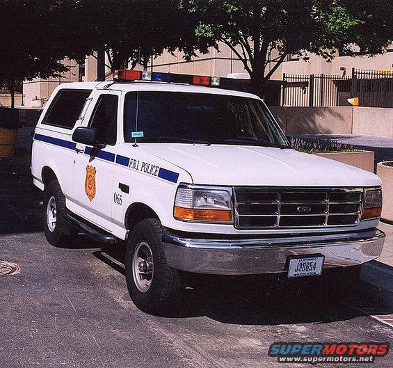 White Ford Bronco police SUV with blue stripe and FBI POLICE text, parked on asphalt