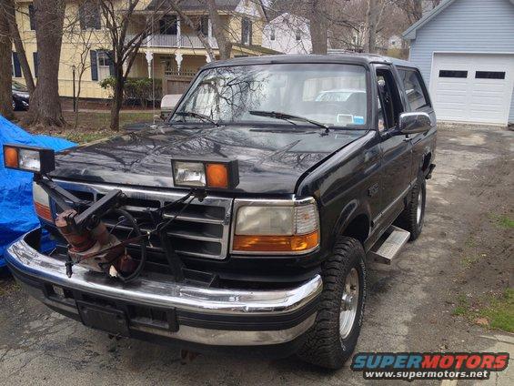 Black Ford Bronco with plow mount and extra lights on the hood