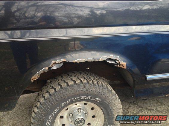 Close-up of rusted rear wheel well on a 1996 Ford Bronco with Goodyear tires
