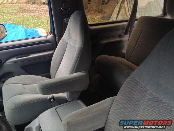 Interior of a 1996 Ford Bronco showing grey cloth captain's chairs and a center console