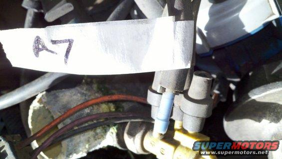 Close-up of engine components with a white label marked "A7" taped to a hose