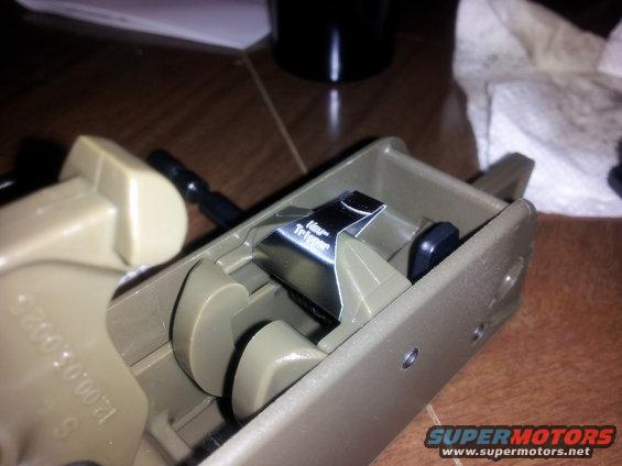 Close-up of a tan plastic housing with a metal component labeled "Hour Trigger"