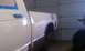 1991 Chevrolet S10 - A white pickup truck is undergoing bodywork in a garage, with its windows taped off for painting.