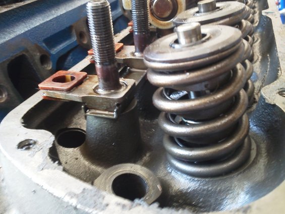 Close-up of engine valve springs and rocker arms, showing metal components and bolts