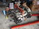 1992 Ford Taurus - Engine assembly being worked on, suspended by a hoist and on an engine stand in a garage.