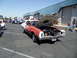 1973 Ford Ranchero - A two-tone red and white vehicle with its hood open is parked at an outdoor event, with other cars and people in the background.