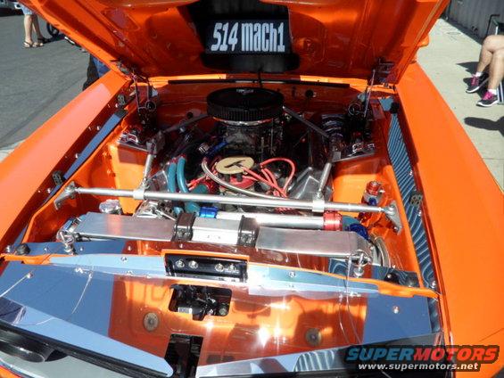 Orange engine bay with "514 mach1" displayed above the engine. Chrome accents and custom hoses are visible