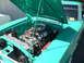 1973 Ford Ranchero - The engine bay of a teal 1973 Ford Ranchero is open, revealing a V8 engine with chrome accents.