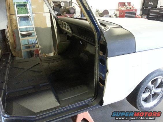 1967 Ford F-100 interior, driver's side door open, showing black floor matting and dashboard