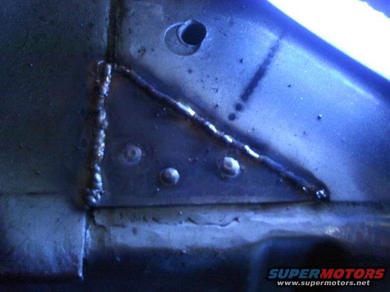 Close-up of a welded metal corner with rivets and a hole