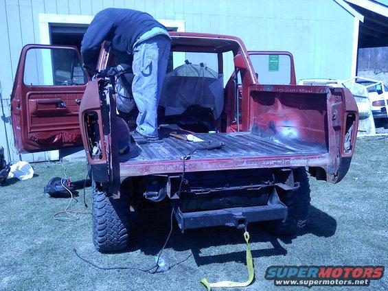 1978 Ford Bronco with bed removed, person working on rear quarter panel