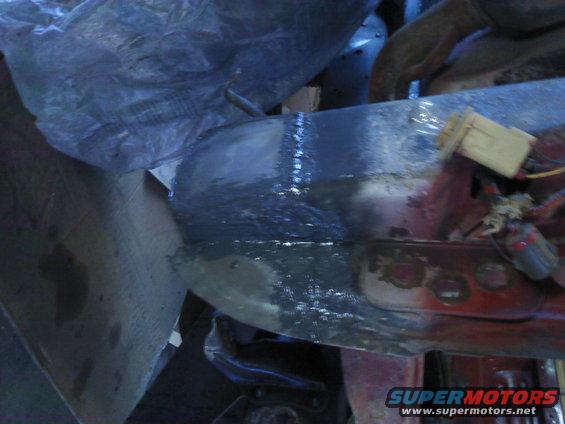 Vehicle frame section with dark grey primer and visible weld marks