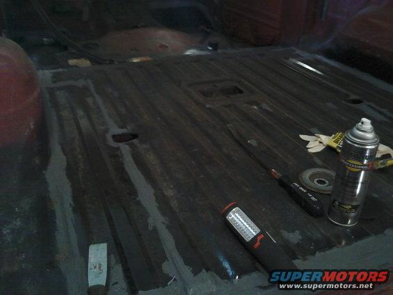 Interior floor of a vehicle with tools and a spray can on it