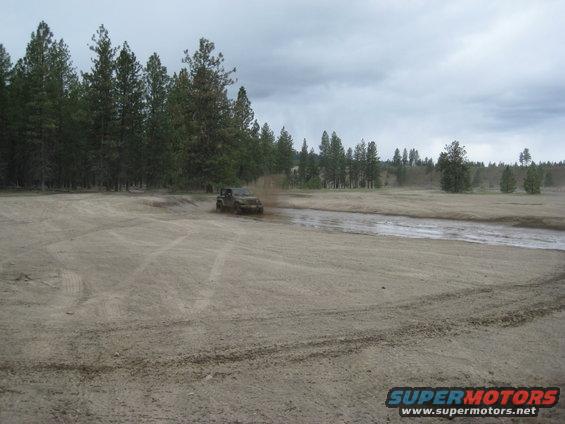 2005 Jeep Wrangler kicking up mud while driving off-road