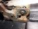 1995 Ford Bronco - This close-up shows a heavily rusted metal bracket with a bolt and a small gap indicated by a red arrow.