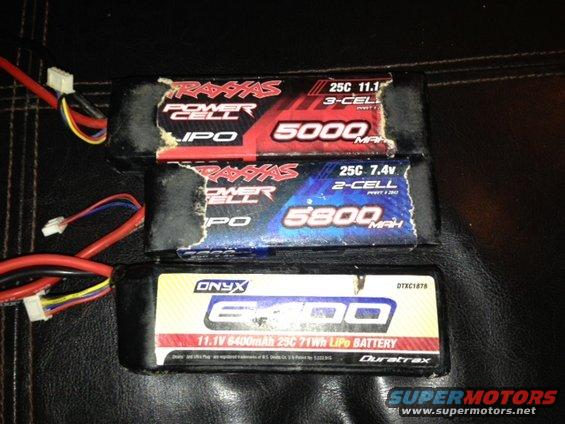 Three RC LiPo batteries with labels showing brand names like Traxxas and Onyx, and specifications like 5000mAh and 7.4V