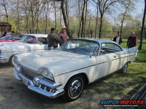 White and blue two-tone coupe with chrome grille and bumper, parked outdoors