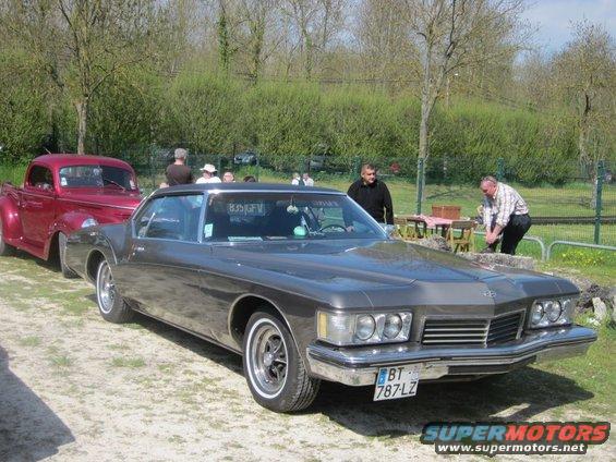 Gray 1973 Buick Riviera parked next to a red pickup truck