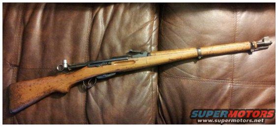 Rifle on brown leather couch