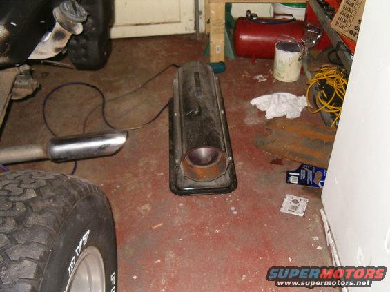 Exhaust pipe and muffler on a red concrete floor