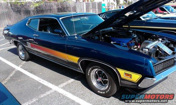 Dark blue Ford Gran Torino Sport with yellow and red side stripes, hood open showing engine