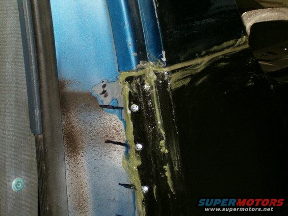 Body panel seam with sealant and rivets