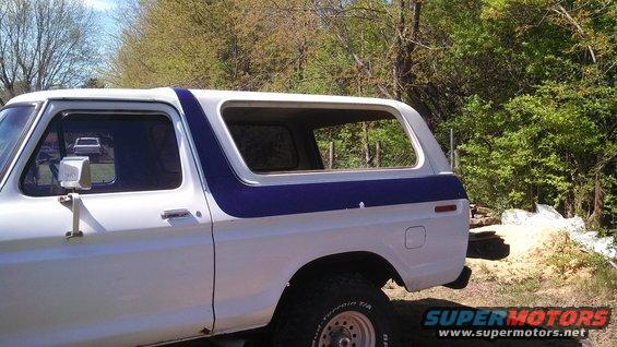 Side view of a white and blue 1979 Ford Bronco with removed rear window