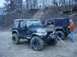 1992 Ford Bronco - Two Jeep Wranglers are parked on a dirt surface, with people standing near them.