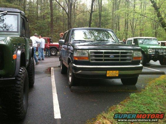Dark blue 1992 Ford Bronco front view, yellow license plate T21156, parked in lot with trees