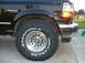 1995 Ford Bronco - A black 1995 Ford Bronco XLT is shown from the front three-quarter view, highlighting its tire and fender.