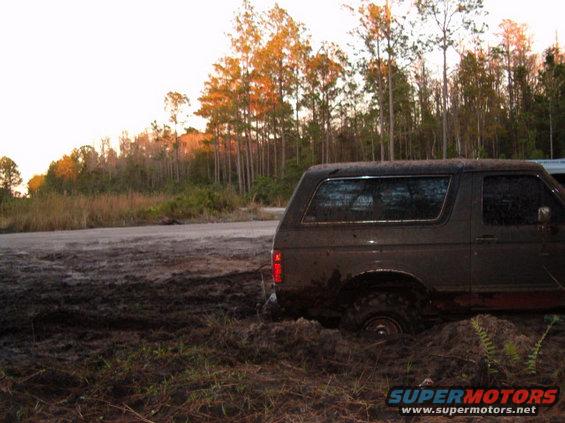 1991 Ford Bronco stuck in mud on a dirt road