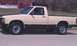1991 Chevrolet S10 - A two-tone pickup truck is parked on the side of the road with a building in the background.
