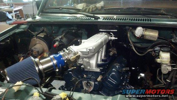 engine bay with blue air filter and silver intake manifold