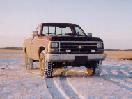 Old pickup truck in a snowy field. Looks like a mid-to-late 80s model