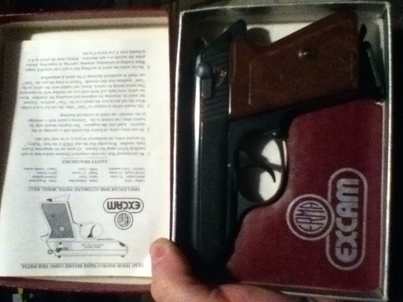 EXCAM pistol in box with manual, showing safety procedures and diagram