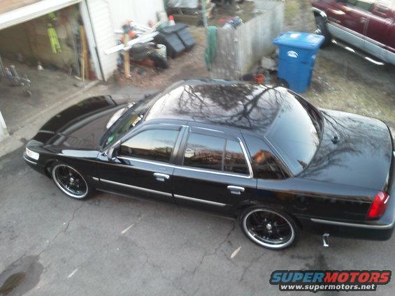 Black sedan with aftermarket wheels parked on asphalt