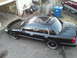 2000 Mercury Grand Marquis - A black sedan, likely a 2000 Mercury Grand Marquis, is parked in a driveway.