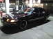 2000 Mercury Grand Marquis - Black 2000 Mercury Grand Marquis with custom wheels at a gas station at night.