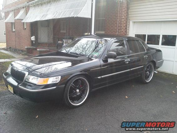 Black 2000 Mercury Grand Marquis with custom wheels parked in driveway