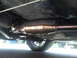 2000 Mercury Grand Marquis - A low-angle view of a vehicle's exhaust system, showing the catalytic converter and part of the muffler.