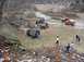 1992 Ford Bronco - Off-road vehicles navigate a challenging muddy terrain with onlookers present.