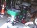 2003 Ford Crown Victoria - A green motorcycle is parked in a garage, a large, open green storage box mounted on the rear.
