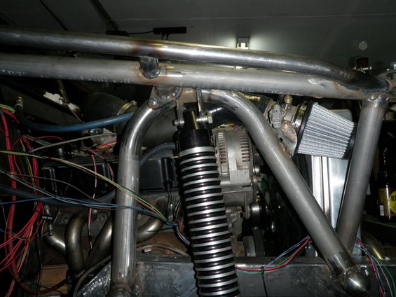 Engine bay with custom metal roll cage, shock absorber, alternator, and air filter