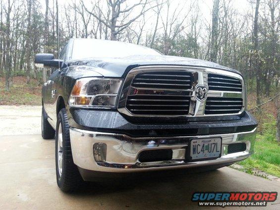 Front view of a black Ram 1500 pickup truck with chrome grille and bumper. License plate reads WC4-U7L